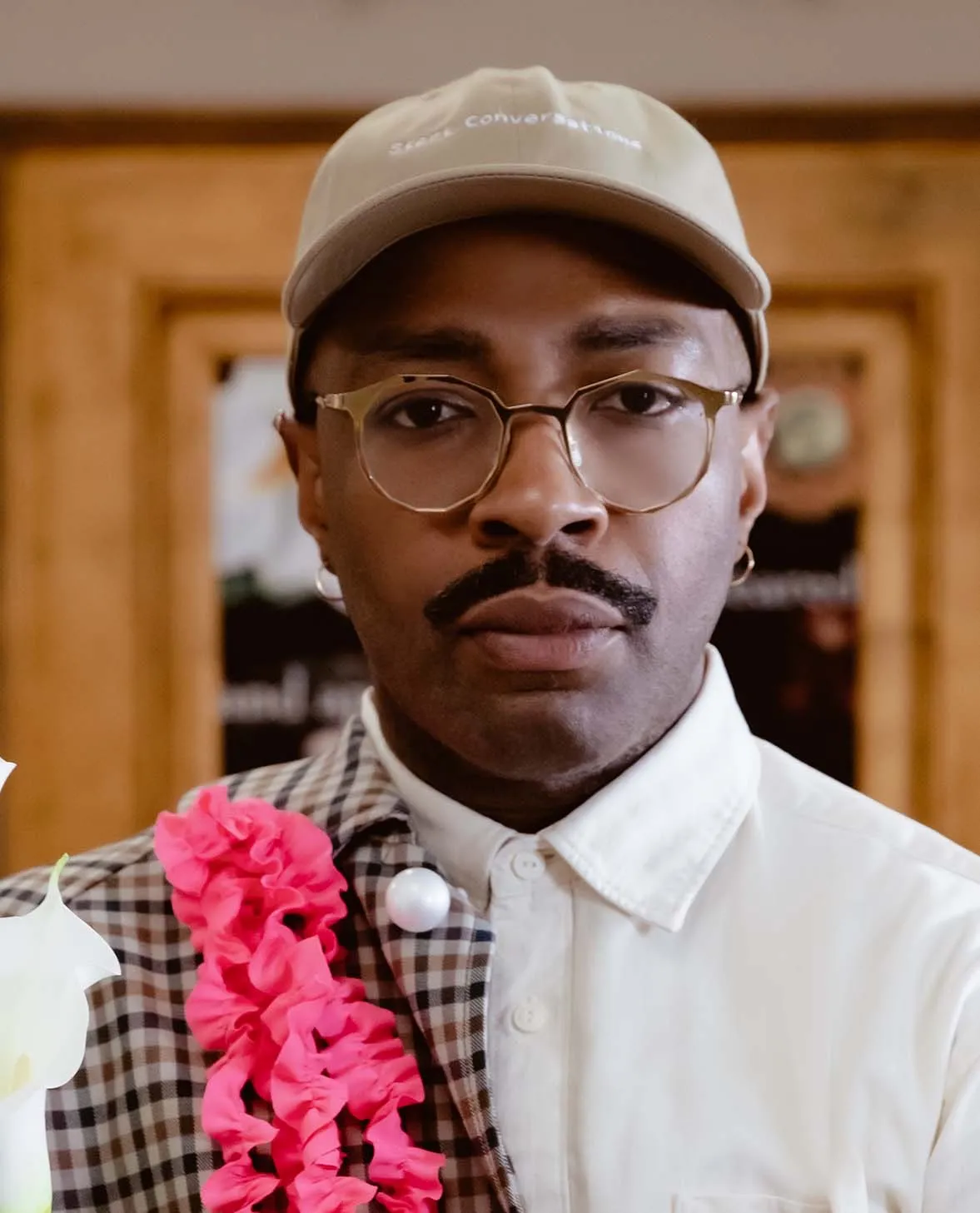 Designer Parron Edwards-Stimola in a cap and pink lei
