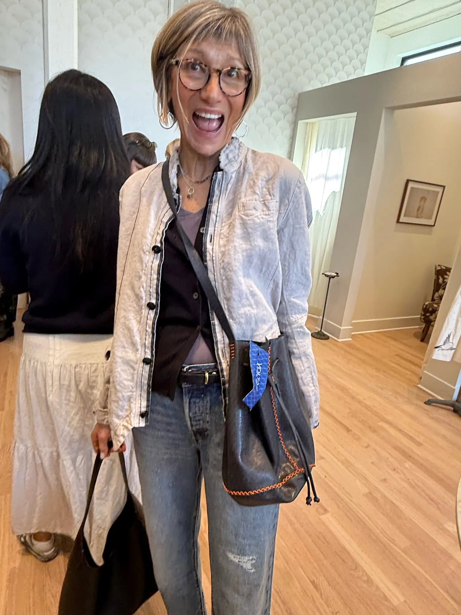 A guest in a pale embroidered jacket, delighted, on the shop floor
