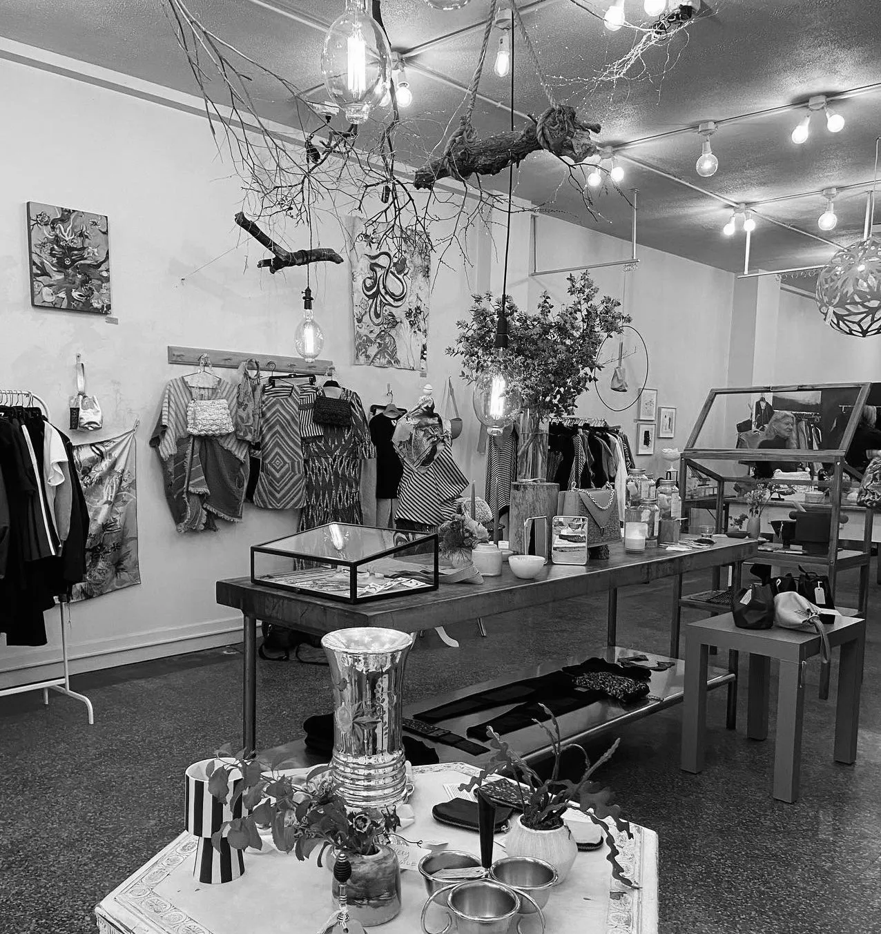 The shop interior — Edison bulbs, branches, racks and mixed textures